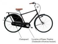 Picture of Recalled Amsterdam Bicycle with arrows pointing toward the Chainguard and the location of the frame number (on the underside of hte bottom bracket)