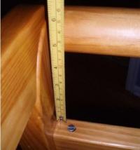 Picture of recalled crib, incorrectly assembled, with ruler showing gap of about 5 inches