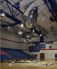 Picture of light pole fallen through gymnasium roof
