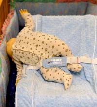 Doll falling over side of recliner placed inside a crib